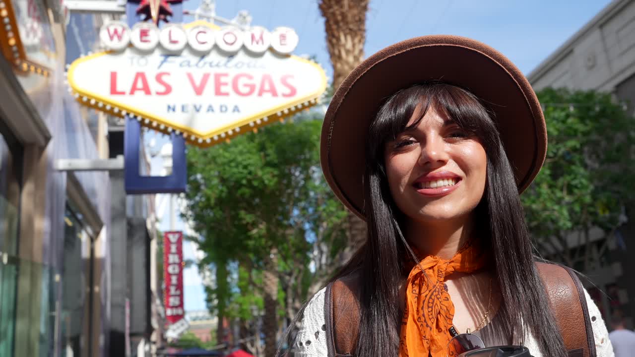 Giovane donna felice in posa con l'insegna "Welcome to Las Vegas"