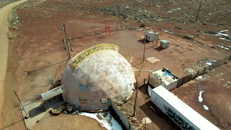 Abandoned-meteor-city-trading-post-on-Route-66-in-Arizona-with-road-and-train-in-background--aerial