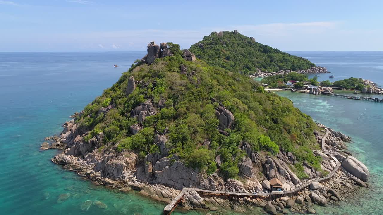 나무 로 된 산책로 와 작은 해변 을 가진 열대 섬 의 공중 풍경