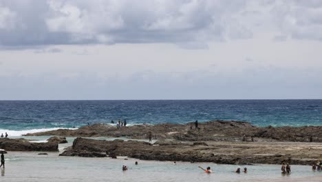 people enjoying a sunny day at a rocky coastline