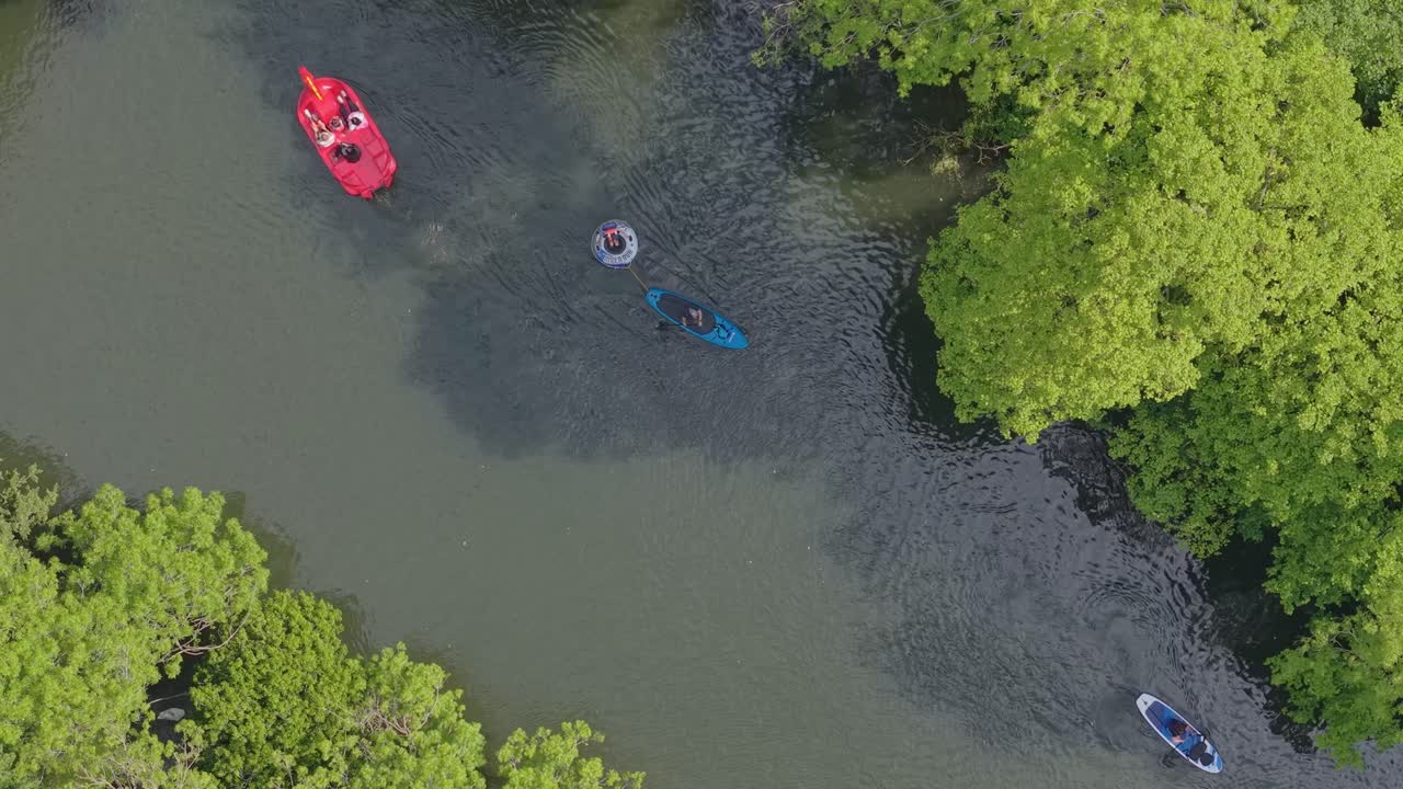 Vista dall'alto del fiume Avon con una canoa colorata che passa lungo le rive verdi, creando un paesaggio fluviale panoramico e tranquillo a Warwick.