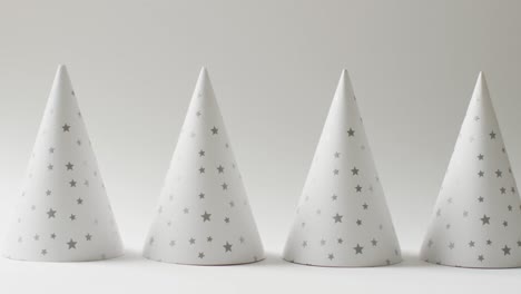 video of a row of white party hats with stars on pale grey background