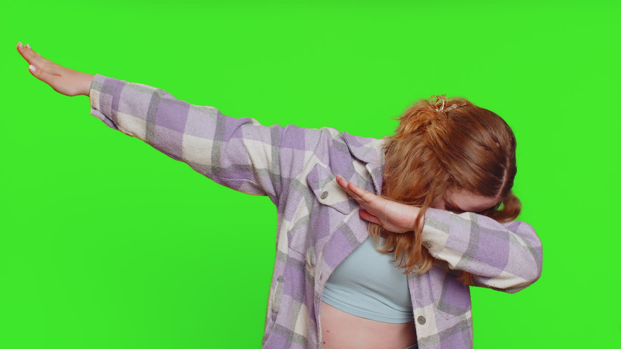 Happy woman having fun dancing, moving to rhythm, dabbing raising hands, making dub dance gesture