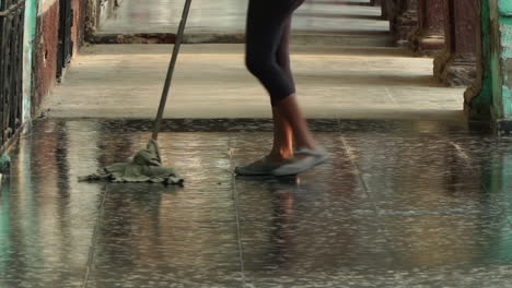 Woman-mopping-outside-in-the-evening-Havana,-Cuba