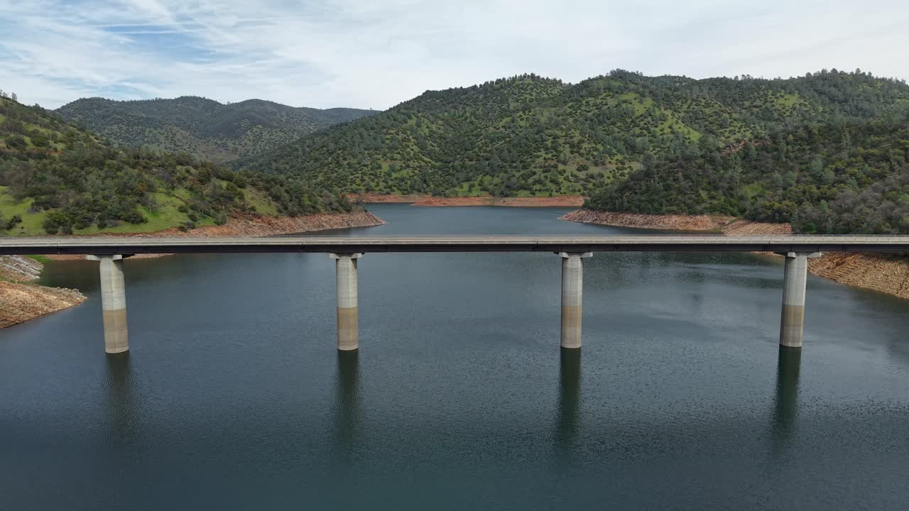 Aerial drone footage captures the Don Pedro Reservoir Bridge in Jamestown, California, spanning the vast lake.