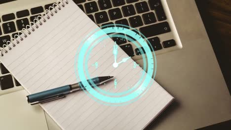 Animation-of-clock-ticking-over-notebook-and-laptop-on-wooden-table