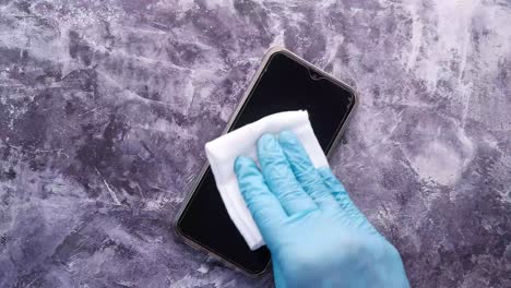 cleaning a smartphone screen with gloves