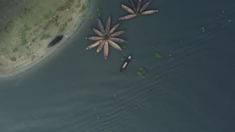 aerial view of wooden boats, arranged in a flower pattern, floating on a majestic river