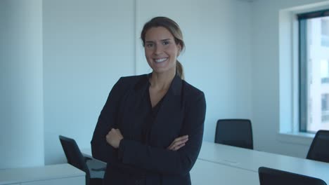 happy confident young businesswoman with arms folded