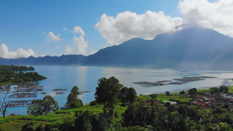 danau batur lake and active volcano gunung batur, with sun rays shining through the clouds