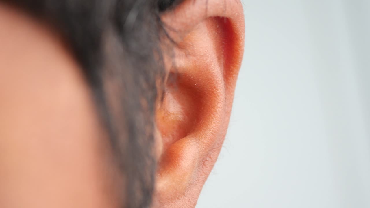 Close-up of a person scratching their ear