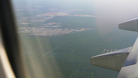 airplane flying over tropical rainforest jungle landscape near cancun city limits outskirts