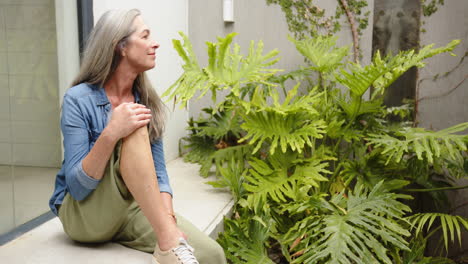 sitting on patio, woman relaxing and enjoying nature next to green plants, copy space