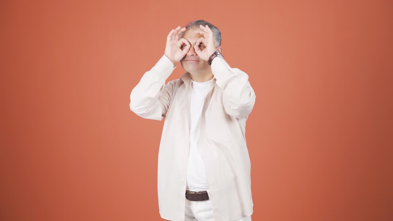 Man with binoculars looking away.