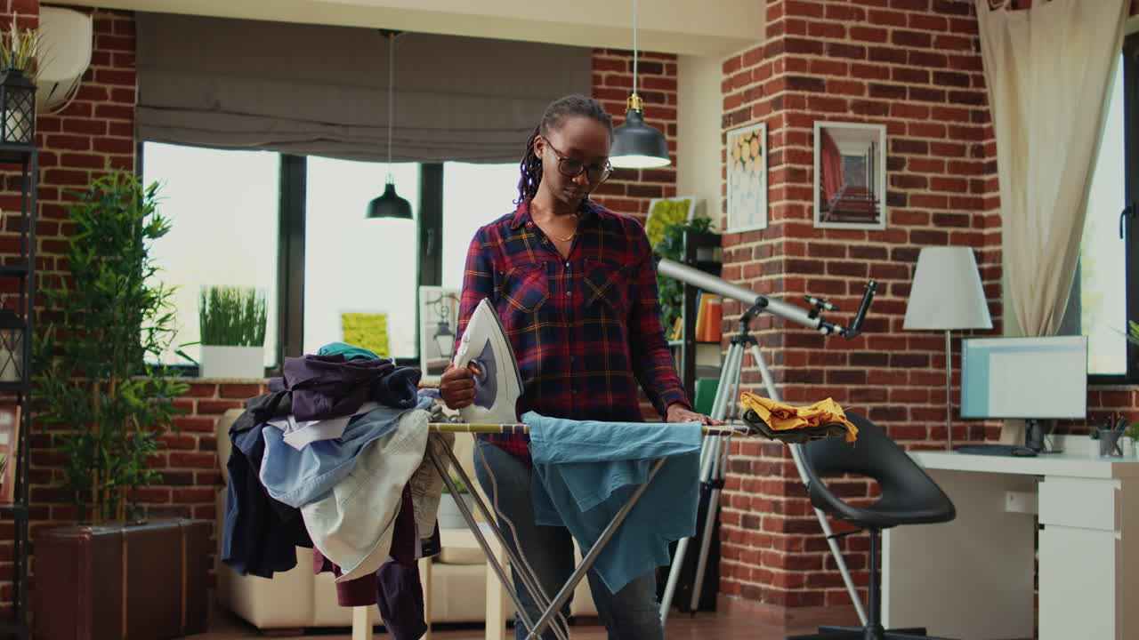 Dissatisfied african american adult does domestic chores without help from partner