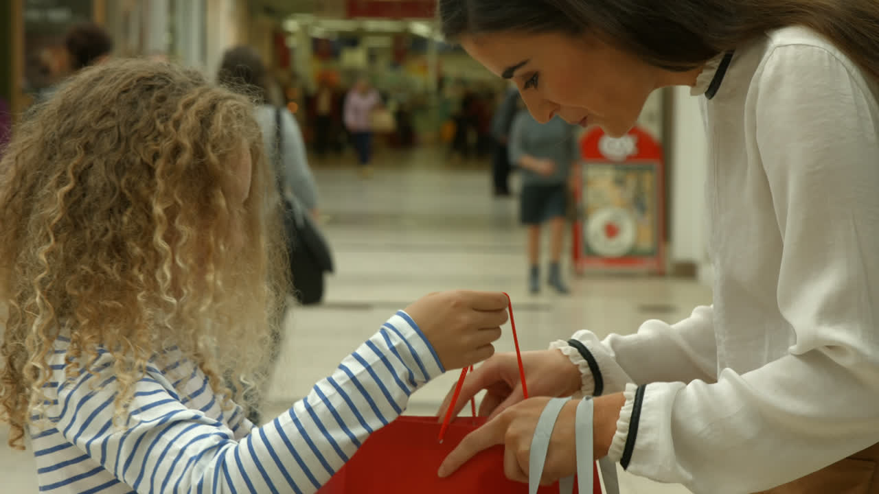 hija mostrando a su madre la bolsa de compras