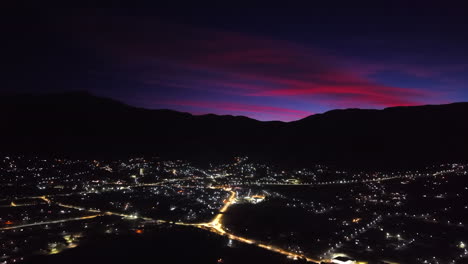 beautiful aerial twilight view of tafí del valle city lights glowing beneath mountain silhouette, tucumán, argentina