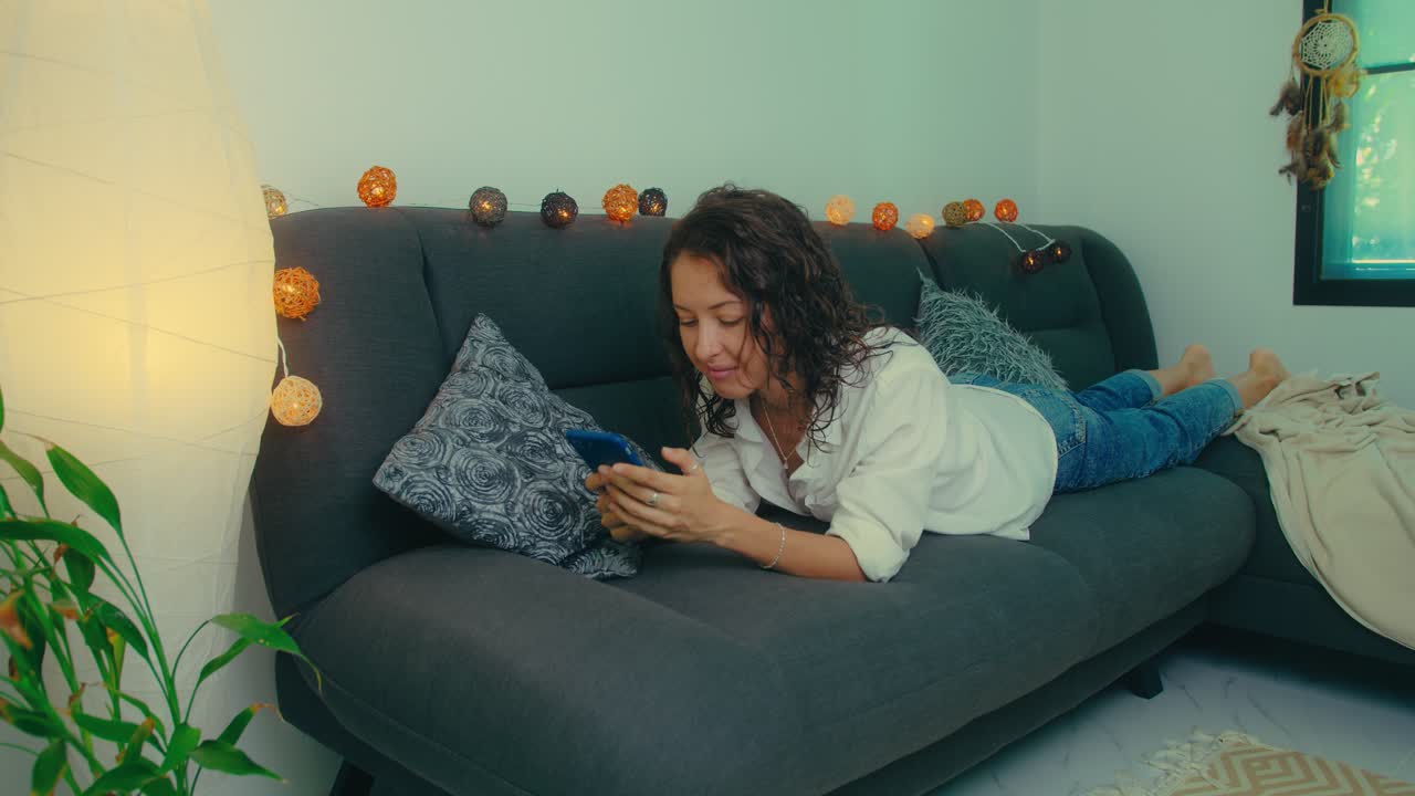 Woman relaxing on a couch with a phone