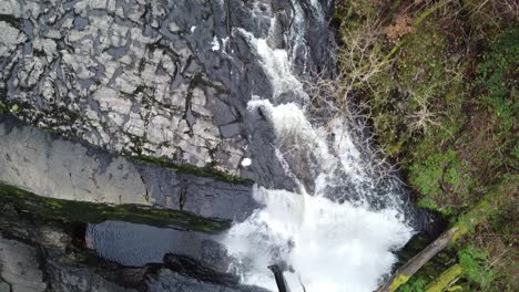 Una-Toma-De-Arriba-Hacia-Abajo-De-Una-Cascada,-Siguiendo-El-Río-Mientras-Pasa-Por-Las-Cataratas