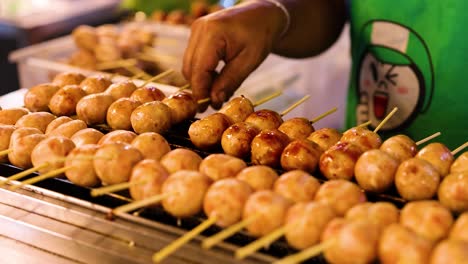 vendor grilling sausages at floating market stall