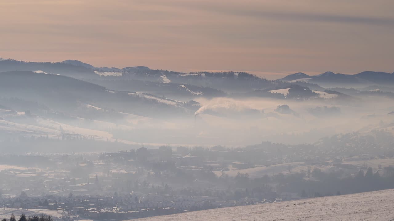 겨울에 산업이 있는 계곡의 안개와 안개로 뒤덮인 마을을 바라보세요