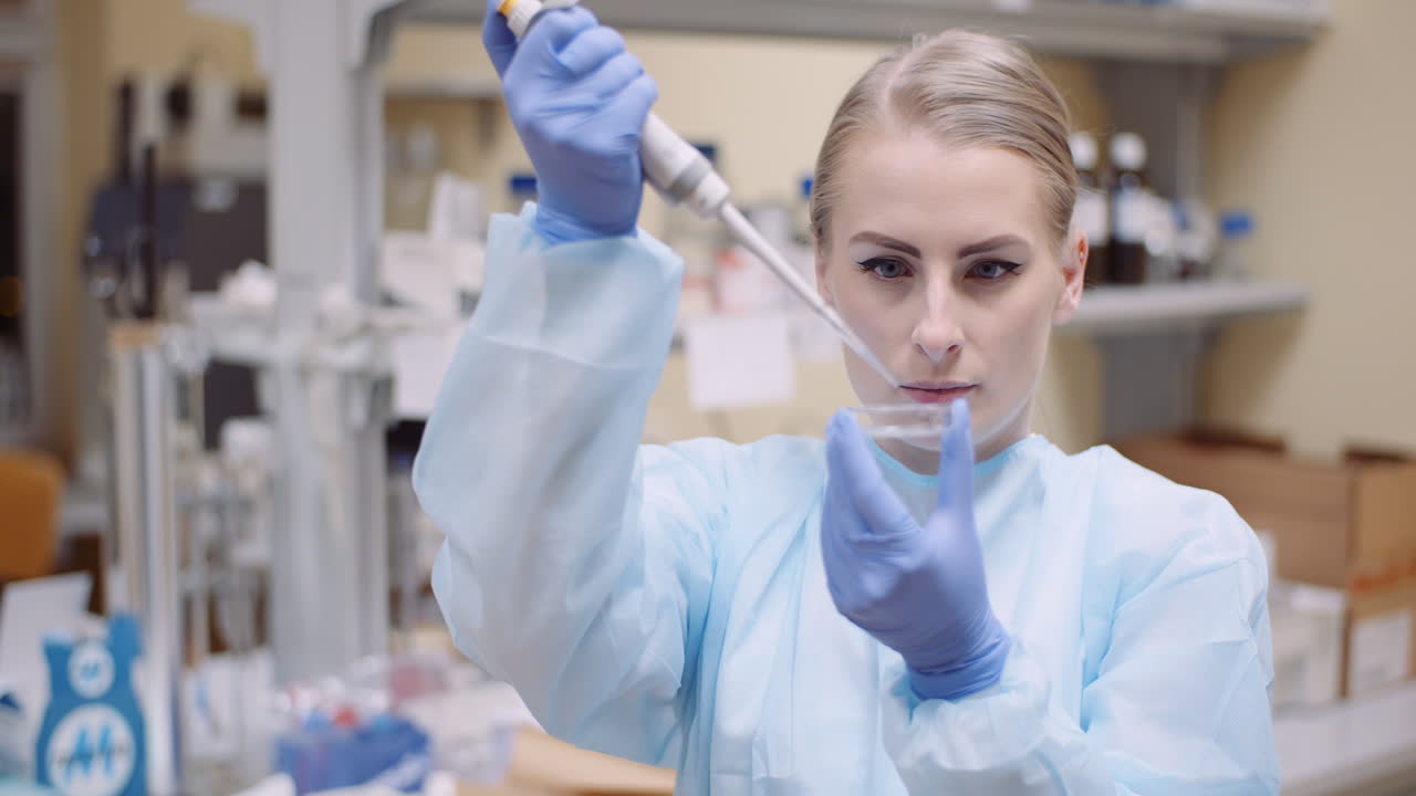 ученый использует пипетку во время эксперимента в лаборатории