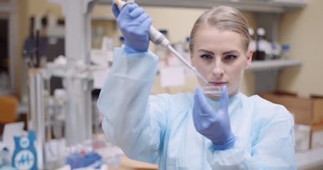 Scientist-Using-Pipette-During-Experiment-At-Laboratory