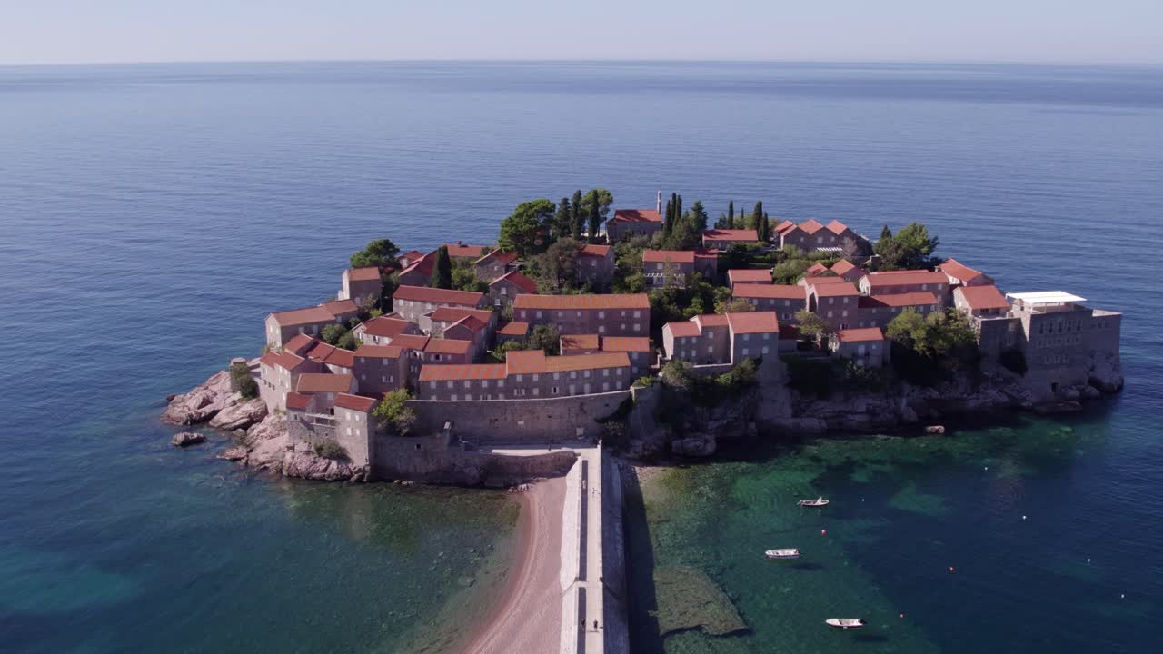 Vista aerea del resort alberghiero Sveti Stefan sulla costa dell'isola a Budva, Montenegro, con una luce splendida, atmosfera tranquilla, riprese con drone di alta qualità che catturano momenti sereni.