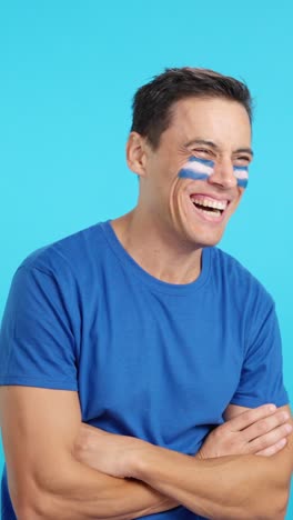 happy man with salvadoran flag painted on face looking away