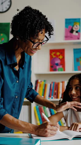 teacher helping student in classroom