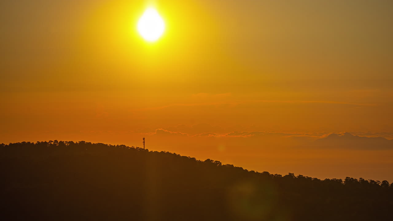 una toma de lapso de tiempo de una puesta de sol y una cizalladura de viento sobre un paisaje forestal
