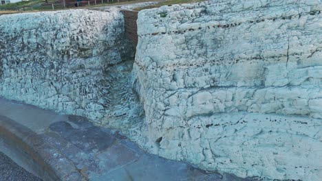 a magnificent cliff rises dramatically from the shore of the english channel