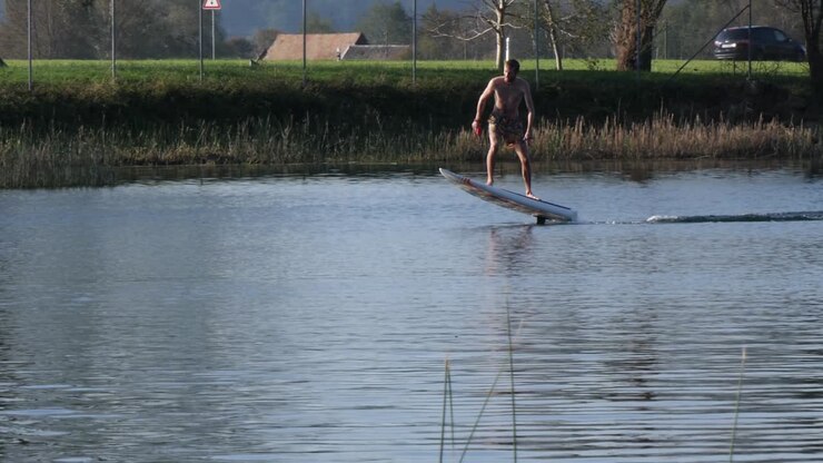 Foil surfing hyrdofoil surfboard rising above waters at Europe