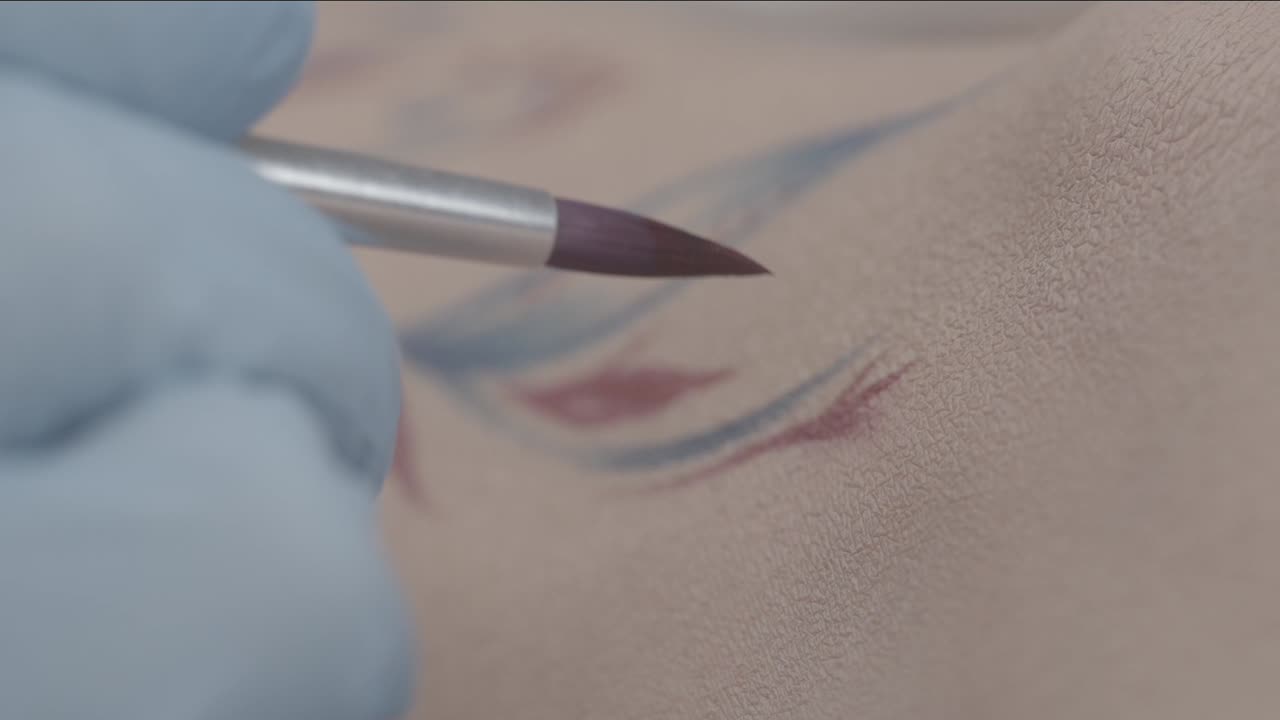 artista del tatuaje delineando un diseño de tatuaje