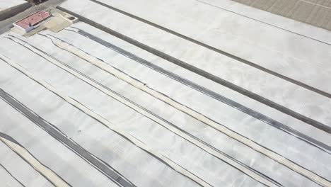 aerial tilt down shot over greenhouses with white plastics in spain