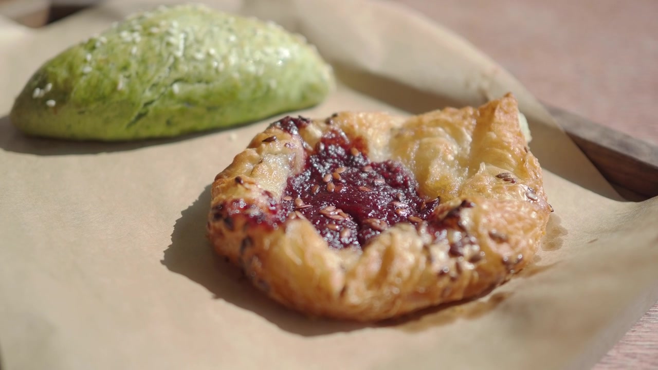 Freshly Baked Berry Danish and Green Tea Bun on a Wooden Tray