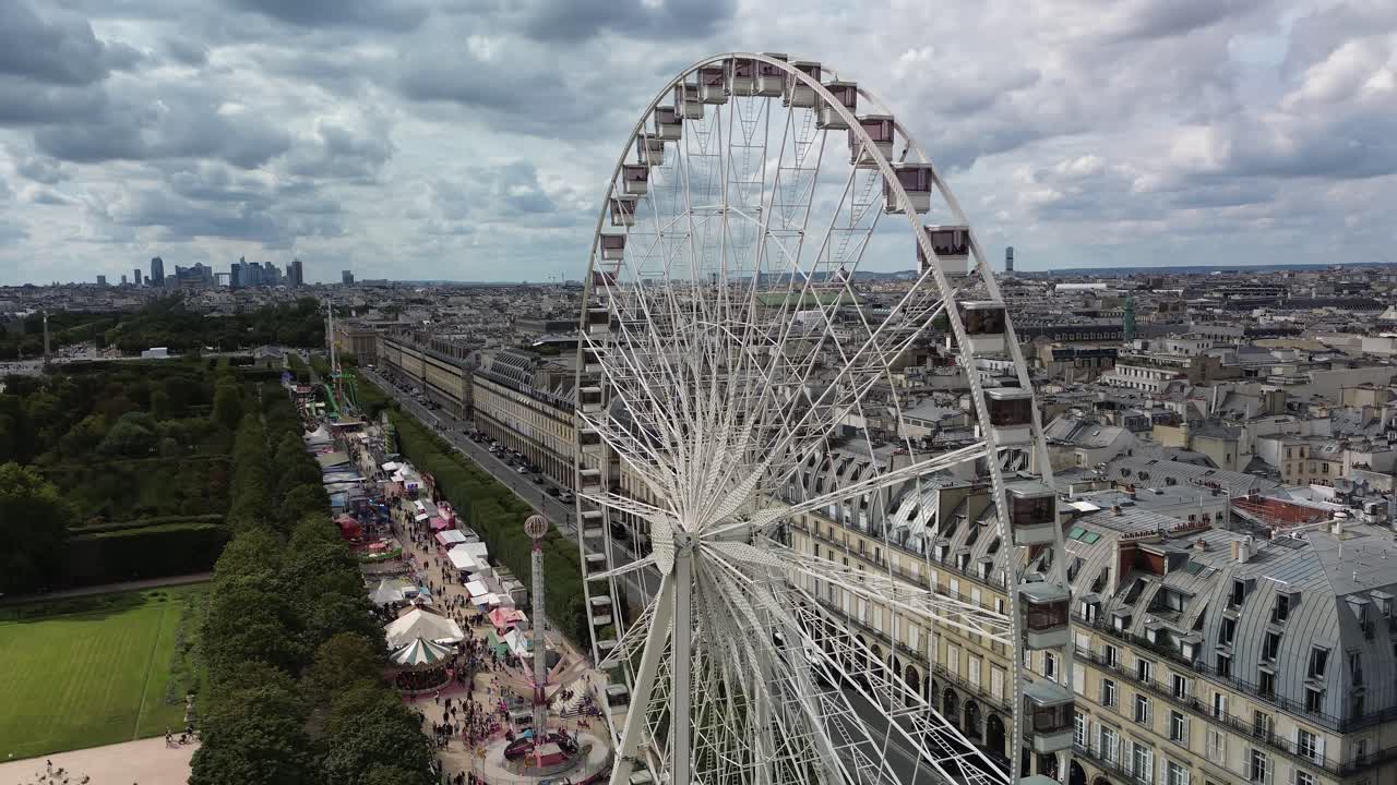 Aerial drone view of Paris cityscape and La D&eacute;fense skyline from Ferris wheel on cloudy day