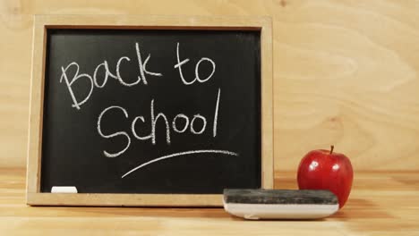 close-up of chalkboard with blackboard duster and apple