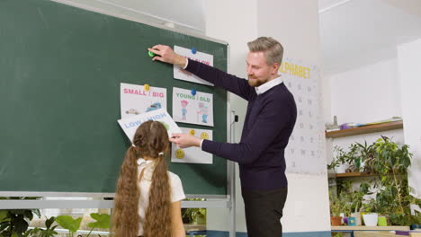 teacher and student in front of blackboard in english classroom