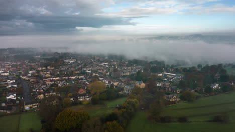 Luftdrohnenhyperlapse-Am-Nebligen-Morgen-Mit-Nebel,-Der-Sich-Durch-Das-Tal-Bewegt,-Und-Sonnigen-Strahlen-über-Feldern-Im-Dorf-Calverley,-Leeds,-West-Yorkshire,-Großbritannien