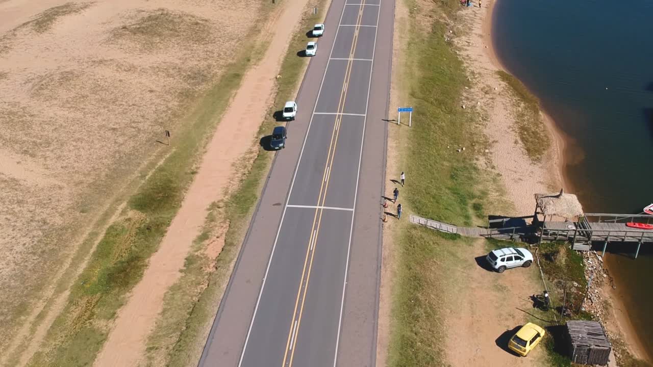 우루과이 말도나도 가르존 바다 위의 다리에서 멀리 있는 길가를 걷고 있는 사람들