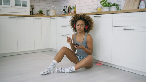 Laughing-woman-with-gadgets-in-kitchen