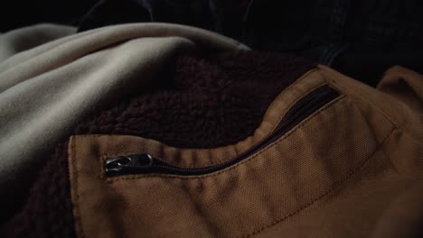 casual jacket of brown color material laying on couch, dolly backward shot