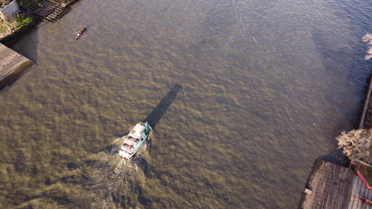 Ripresa aerea dall'alto di una barca che naviga sul fiume nella zona di Tigre a Buenos Aires al tramonto.