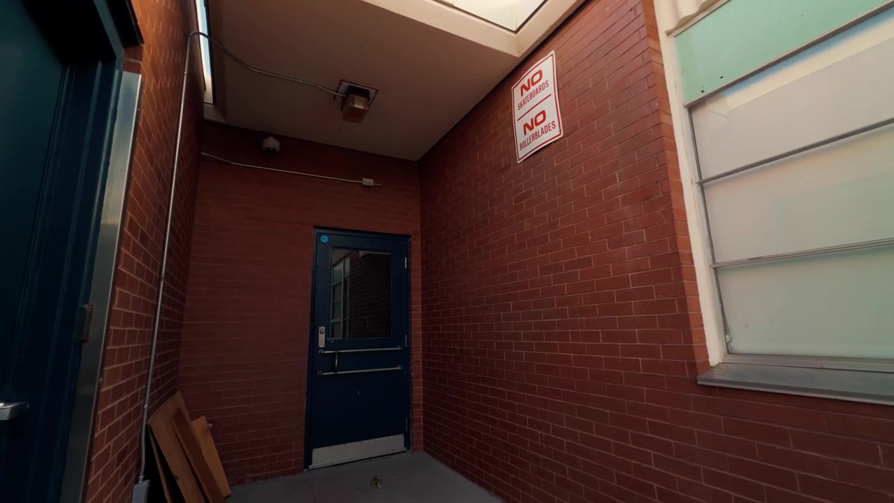 Slow steady forward glide through a covered red brick entrance.