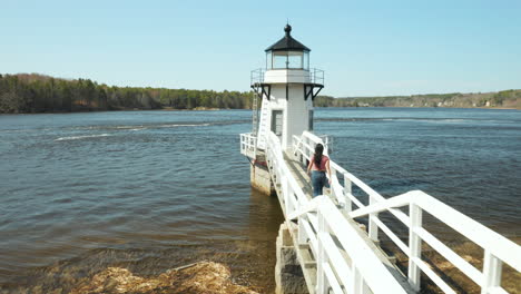 Mujer-Caminando-Por-La-Pasarela-Del-Faro-En-El-Faro-Del-Punto-De-Duplicación,-Arrowsic,-Maine,-Estados-Unidos