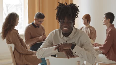 cheerful african-american man at group therapy session