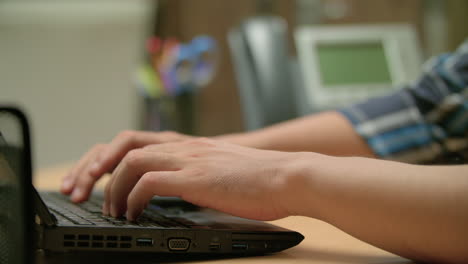 toma lateral de un hombre escribiendo en su computadora portátil y cerrándola.