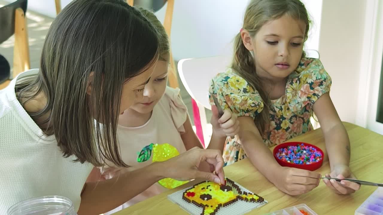 madre e hijas haciendo pixel art