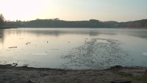 Young-man-doing-warm-up-with-a-swimwear-after-getting-out-of-the-frozen-lake